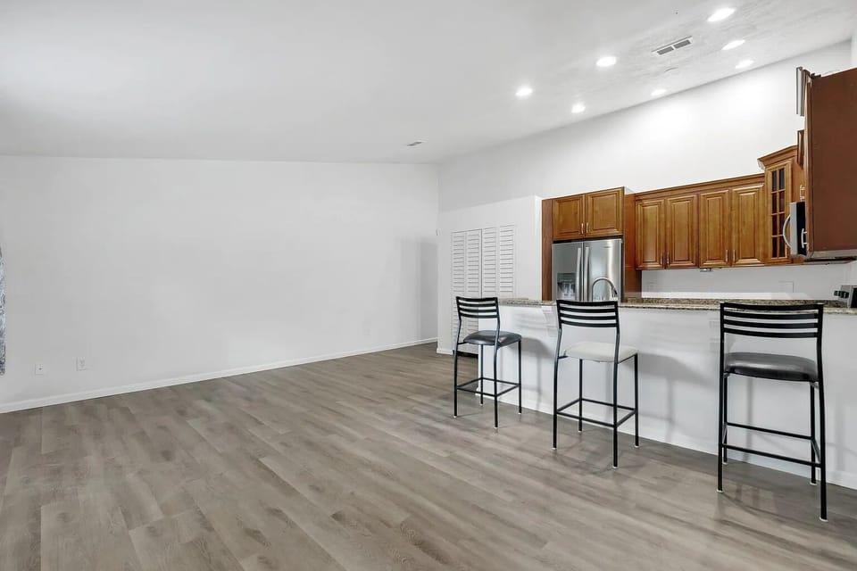 Spacious kitchen area with bar seating and bright overhead lighting