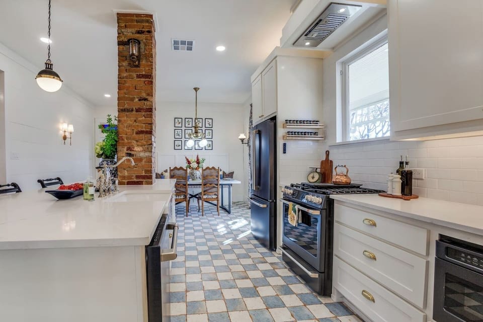 A chef-inspired workspace equipped with premium GE Café appliances, including a sleek matte-black gas range and French door refrigerator.