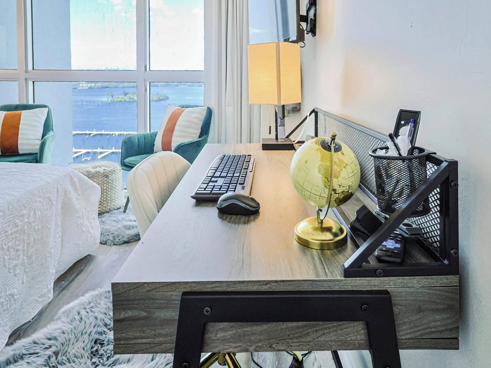 Close-up of a room desk setup with a globe and water view.