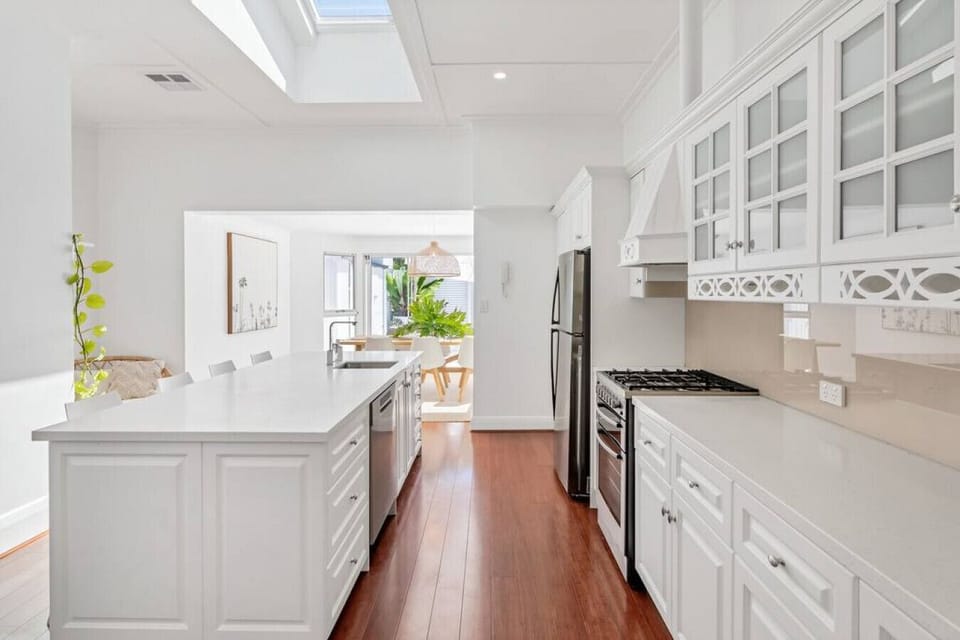 Start your mornings in the bright full kitchen, where generous bench space and crisp white cabinetry make everything from beach breakfasts to shared dinners feel easy and relaxed.