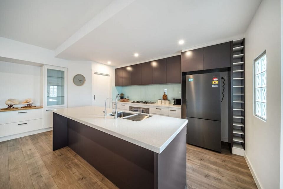 Prepare meals with ease around the expansive island bench, designed for both cooking and casual conversation.