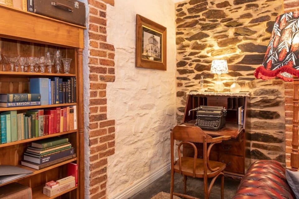 A writing desk with a manual typewriter and a curated library offers a calm space for creative work.