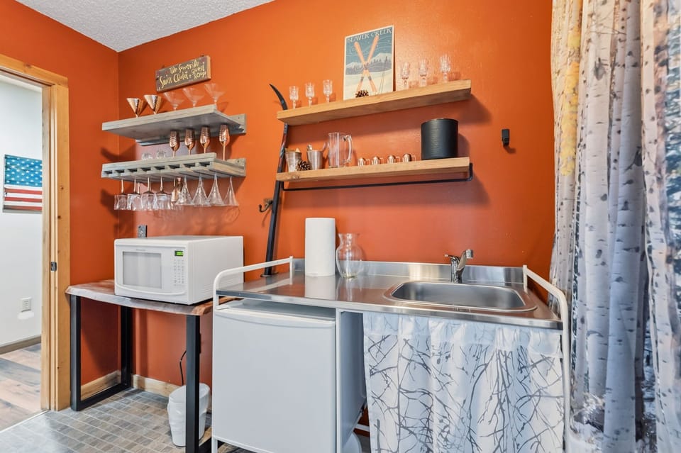 Bar area: Lower floor, kitchenette with sink, microwave, mini fridge, glassware, and copper mugs  perfect for après-ski cocktails