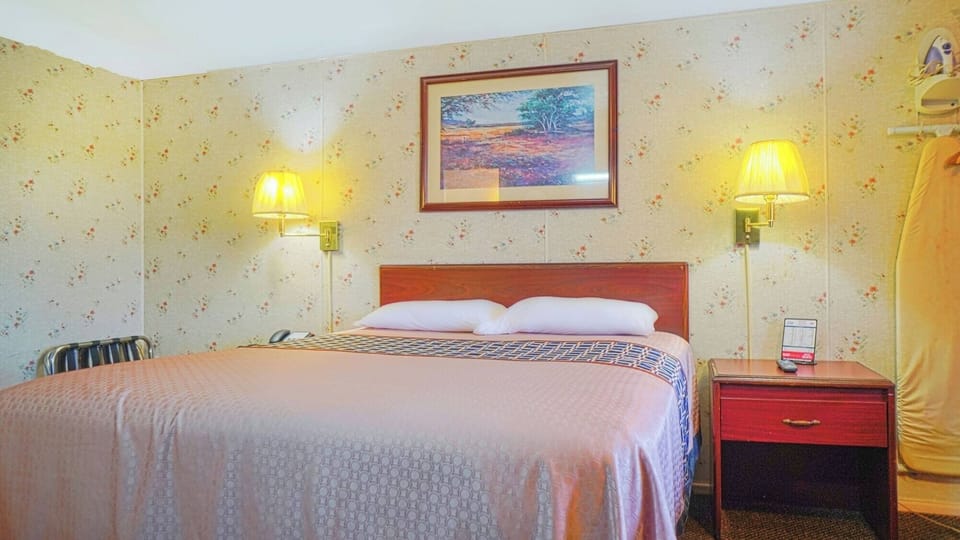 Drift off under warm bedside lighting in a simple room.