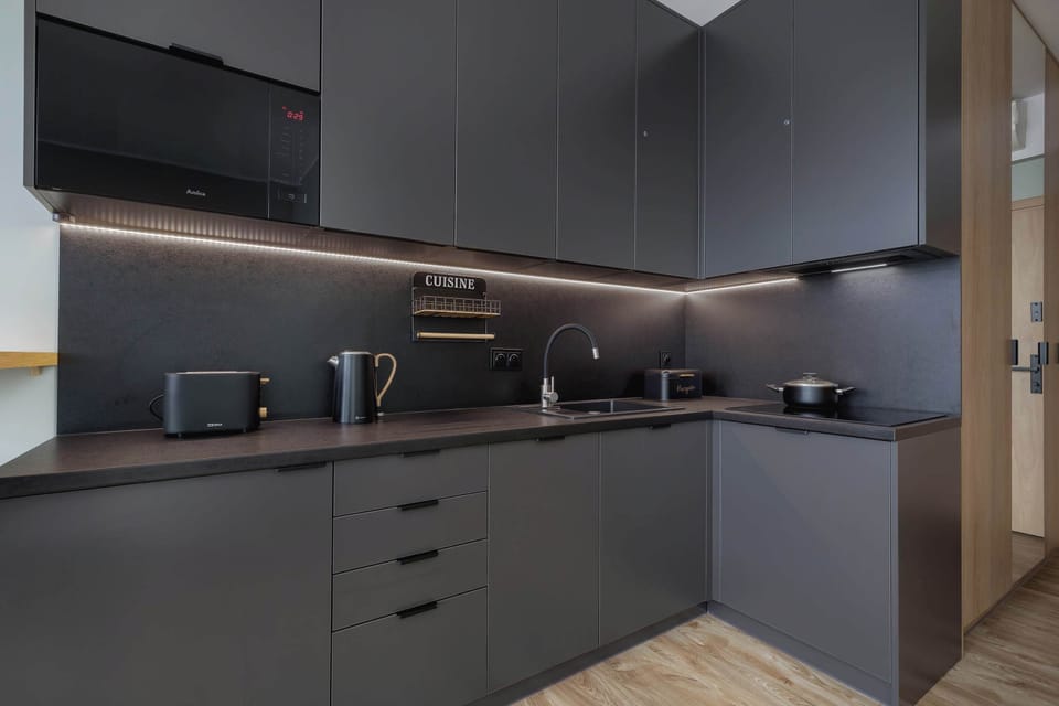 Sleek, contemporary kitchen space with dark cabinetry and high-quality appliances.