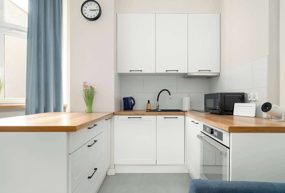 The modern kitchen in white and wood tones provides everything you need for convenient meal preparation.