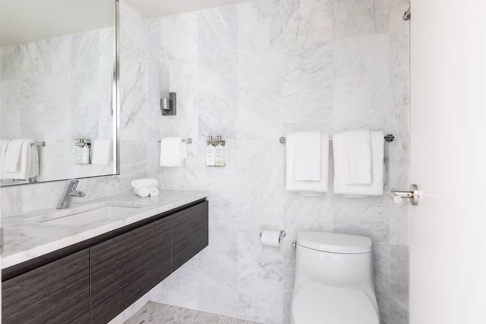 Refresh in a sleek marble bath with plush towels.