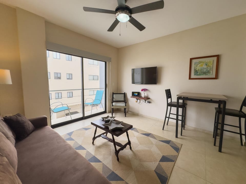 Bright living room, air conditioned with queen sofa bed seating and small balcony access