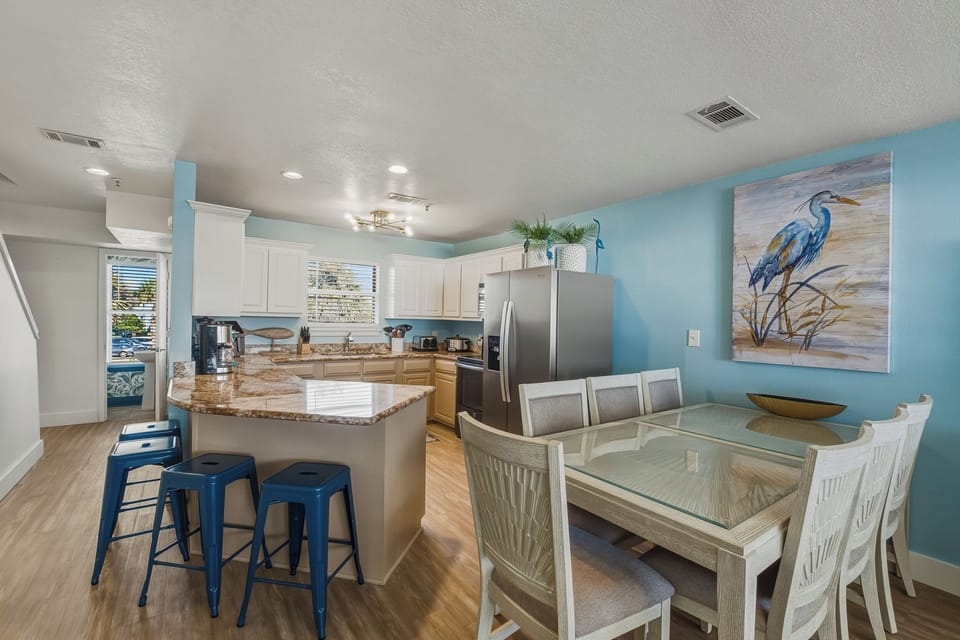 Dining table seats 7, with 4 barstools at counter and ample living room seating.