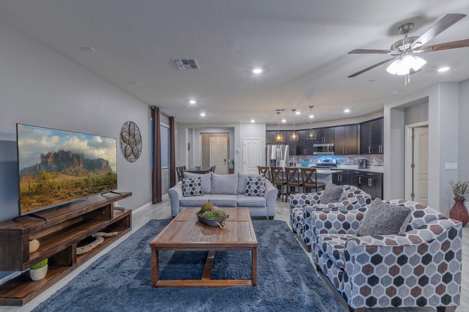 The open concept great room has a sitting area with TV, fully stocked kitchen and dining area.