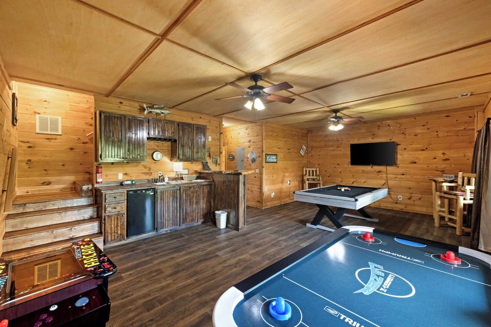 lower level game room with wet bar, pool table, air hockey table, and arcade