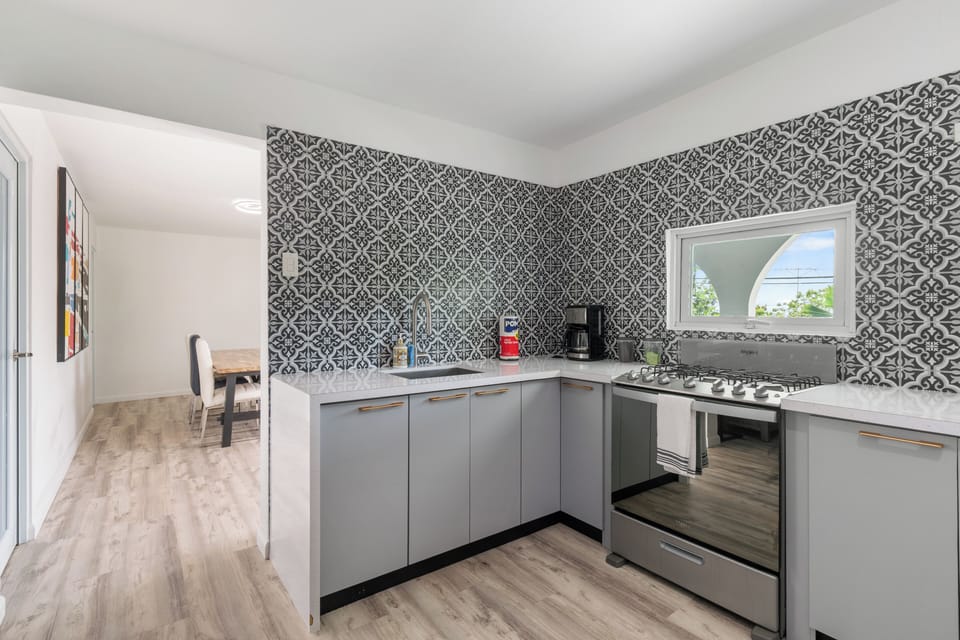 A modern kitchen with a stylish backsplash and ample room for food prep.

