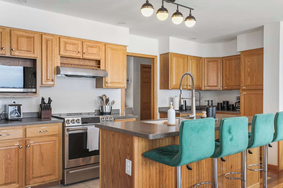 Fully stocked kitchen with counter height barstools, and complimentary coffee, tea, and sugar.
