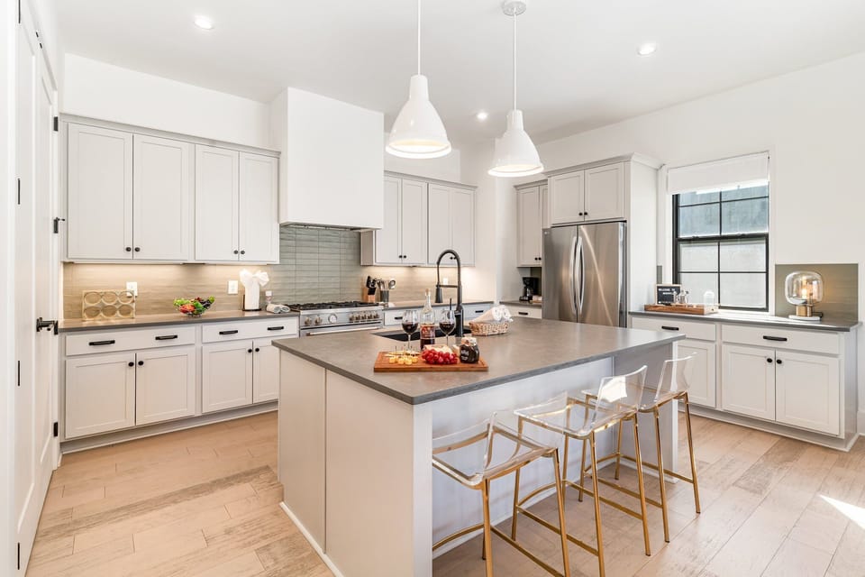 2nd Floor: Fully equipped kitchen with stainless-steel appliances and a kitchen island offering ample counter space and bar seating.