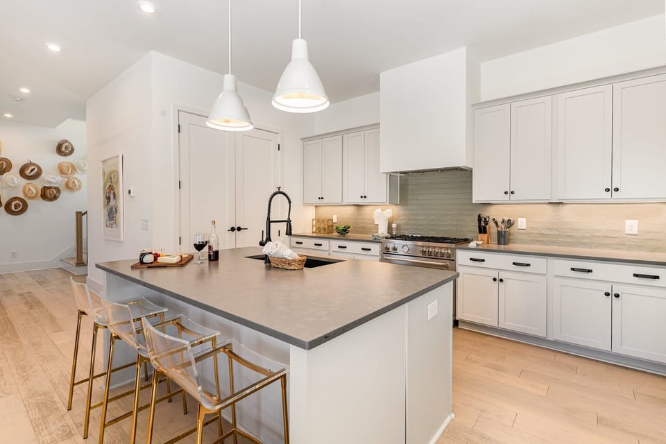 2nd Floor: Fully equipped kitchen with stainless-steel appliances and a kitchen island offering ample counter space and bar seating.
