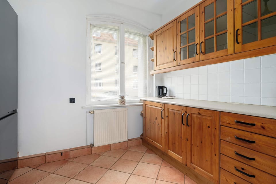 Another view of the kitchen, showing ample storage and countertop space. The window allows natural light to brighten the room.