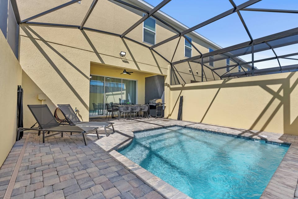 Step outside to your private oasis with a sparkling pool, stylish pavers, and a modern screened enclosure. Relax on elegant lounge chairs under the sun, making it the perfect spot for leisurely afternoons in a serene setting.
