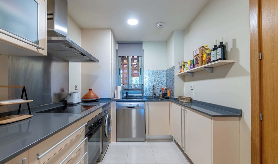 A bright and tidy kitchen with a window view. Neutral color palette with stainless steel accents. Ready for cooking up delicious meals! 🍽️ 