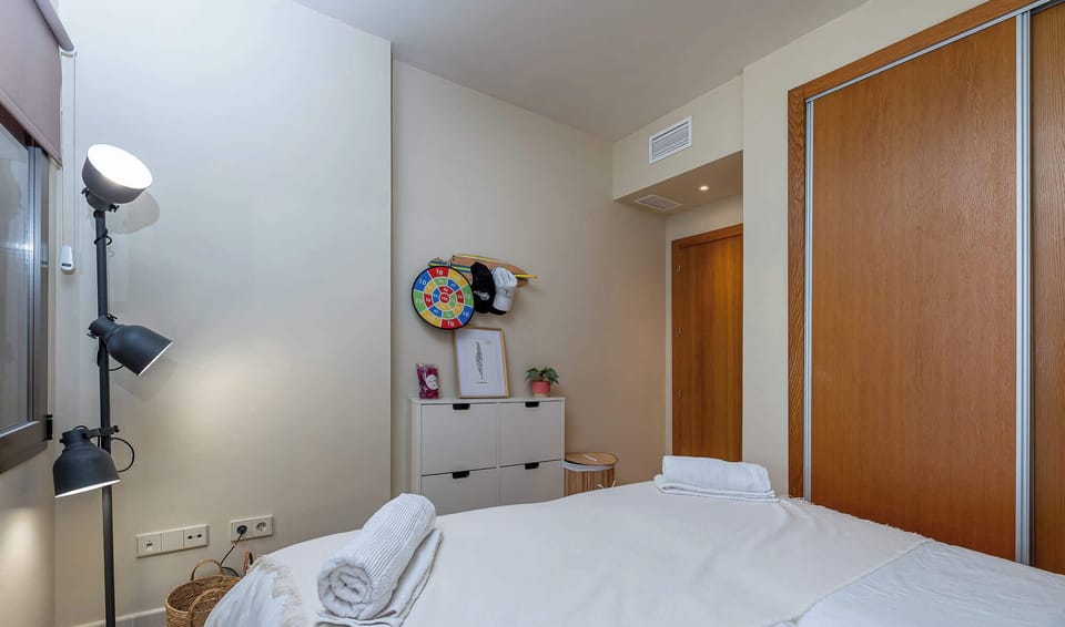 Clean and simple bedroom design with white walls, blue accents, and minimal decor. A peaceful and uncluttered space. 