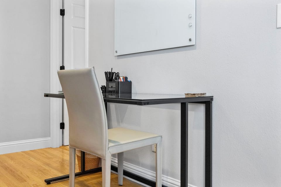Spacious desk located next to outlets. Basic office supplies.