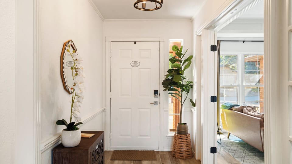 Step into warmth and comfort — this inviting entryway sets the tone for a relaxing stay, blending natural light, greenery, and thoughtful touches that make you feel right at home.