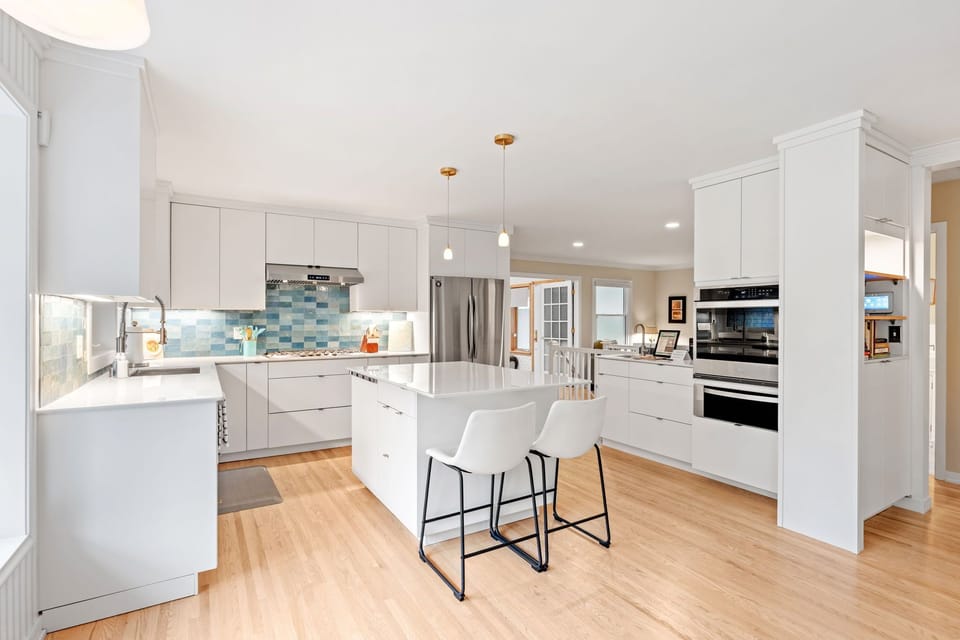 Discover your dream kitchen with sleek white cabinets, granite countertops, and modern appliances perfect for preparing memorable meals during your stay.