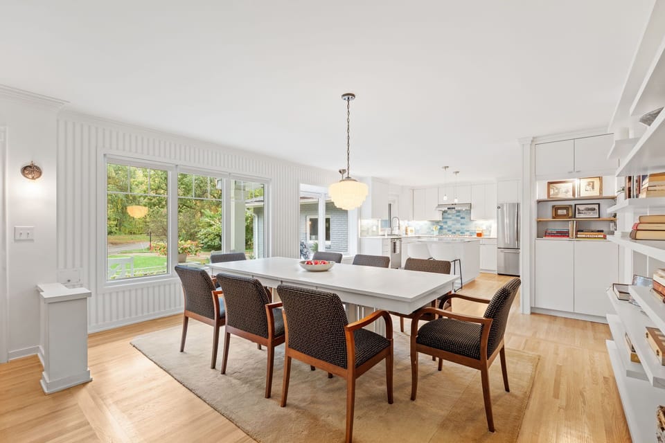 Gather around this elegant dining table for memorable meals together, with natural light streaming through large windows.