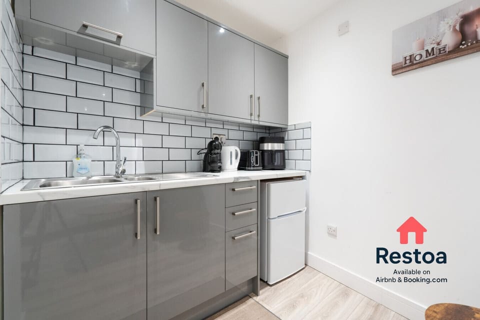 Sleek kitchen corner with fridge, kettle and cutlery