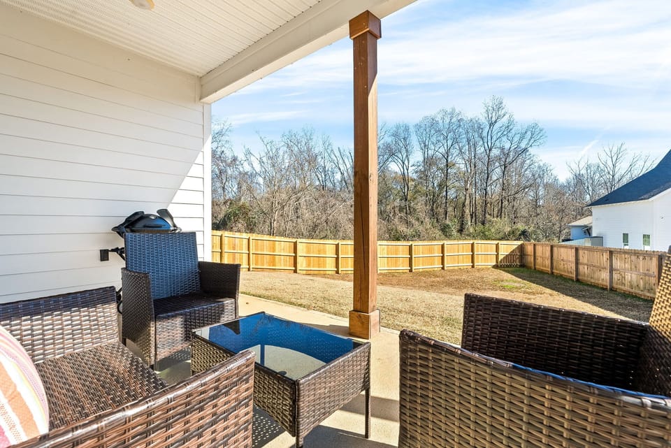 Back covered patio with gas grill and seating area
