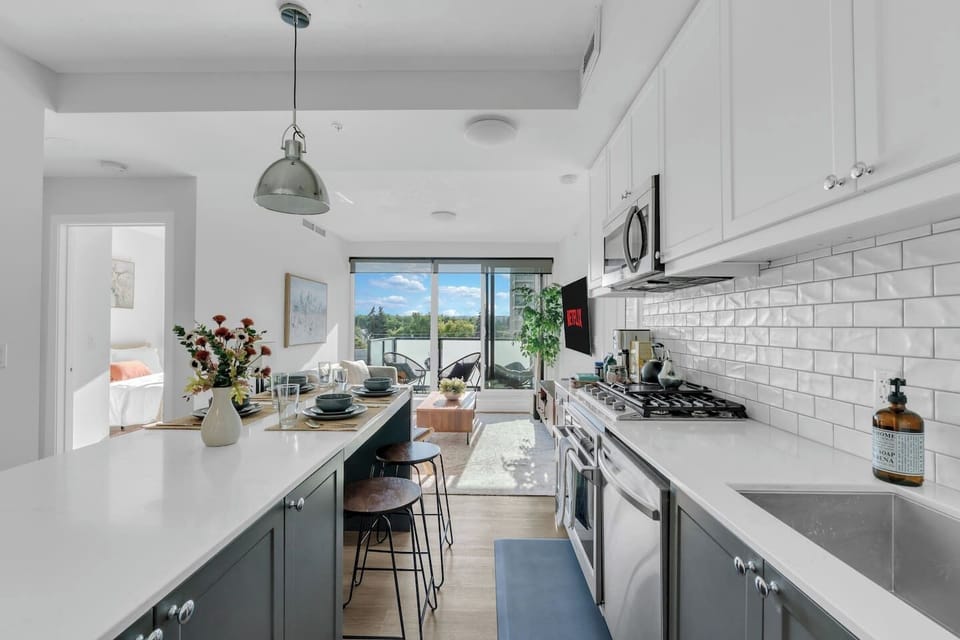 Gourmet kitchen bathed in natural light, complete with premium appliances, curated essentials, and a sleek island for dining or entertaining.