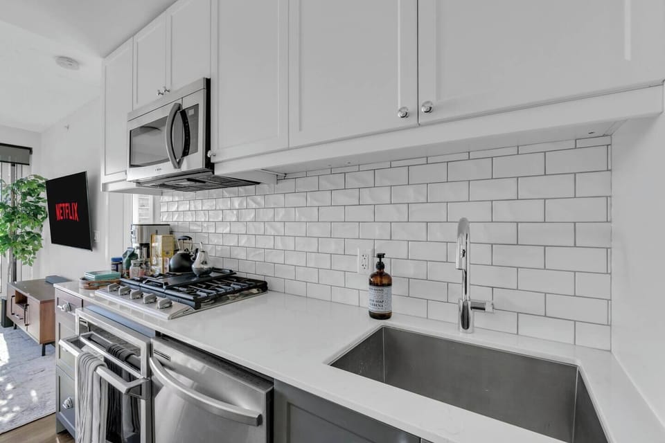 Gourmet kitchen bathed in natural light, complete with premium appliances, curated essentials, and a sleek island for dining or entertaining.