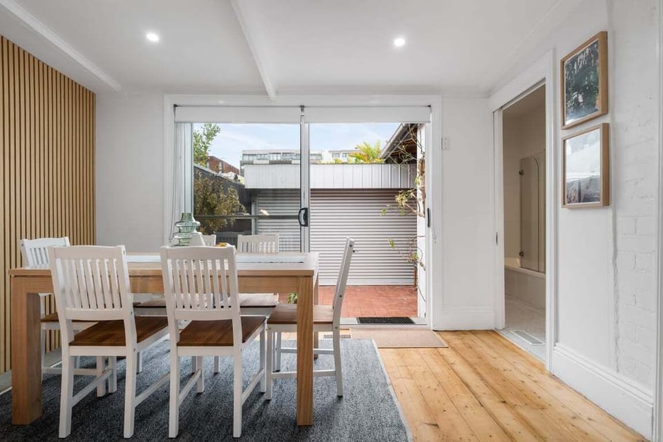 DINING: The rear dining room opens to the outdoor courtyard which provides parking for a small car and has an outdoor table setting.