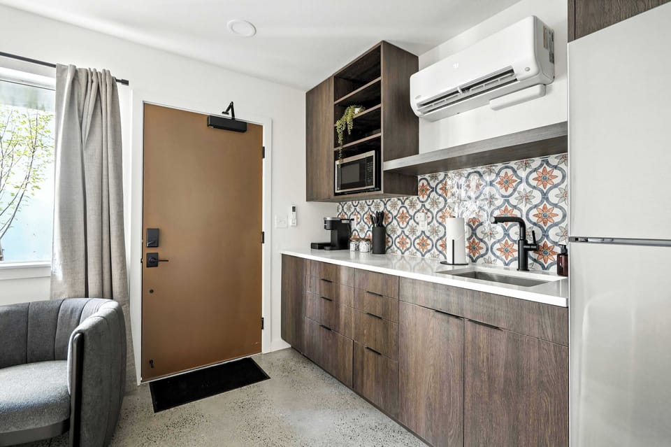 Kitchen counter with patterned tile and front entry.