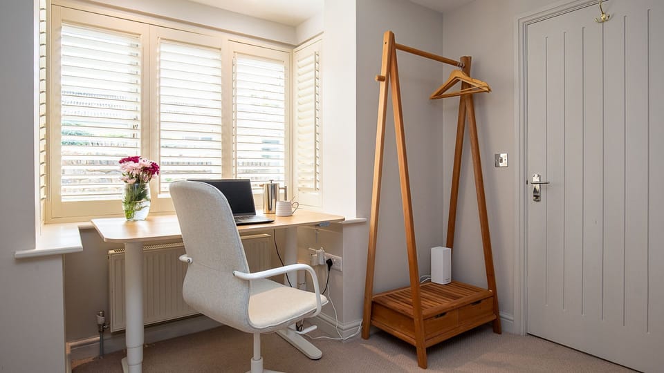 A quiet corner, the office has a desk which can be used as a standing desk and a chair.