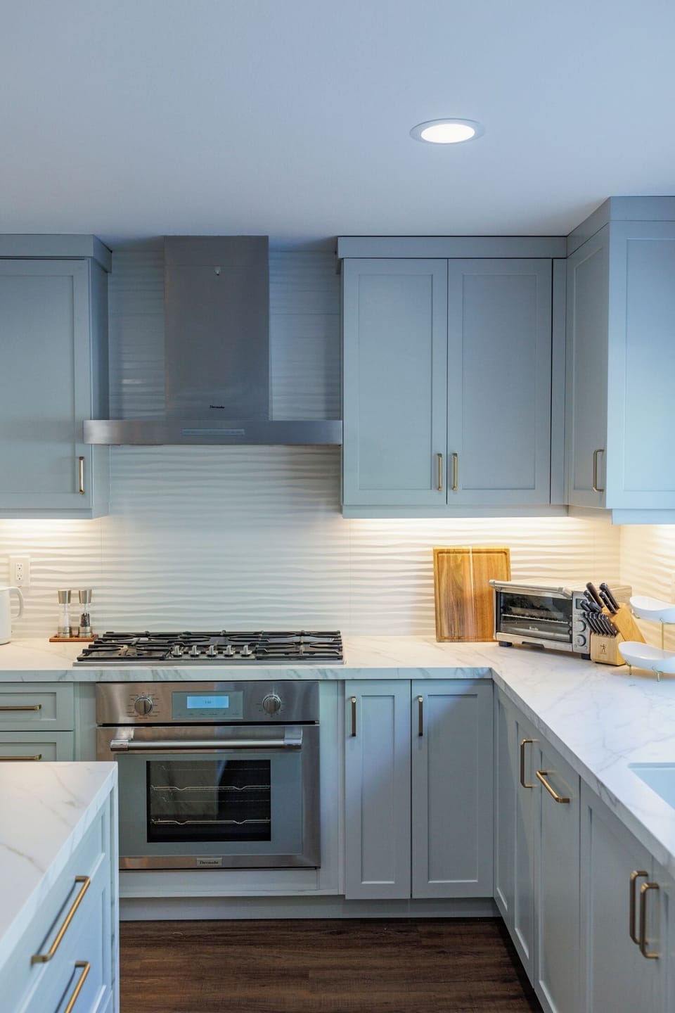 Kitchen features stainless steel appliances with backsplash and cabinetry.