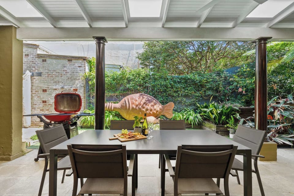 The spacious alfresco area opens directly onto the lush lawn and features a stylish outdoor setting with seating for up to six. Perfect for leisurely gatherings, it also includes a dedicated barbecue space for relaxed outdoor dining and entertaining.