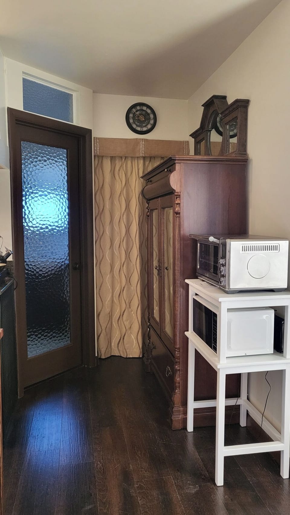 Cozy nook with vintage armoire and handy appliances.