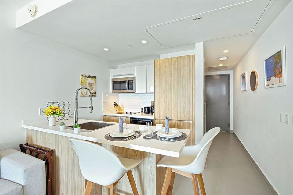 Your modern kitchen awaits, complete with sleek appliances, a cozy breakfast bar for two, and bright, airy space to prepare meals and gather over morning coffee.