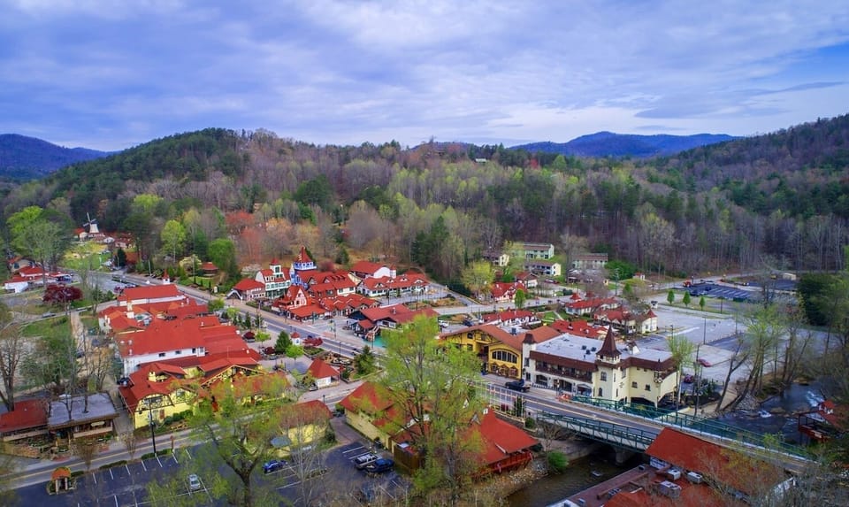 Gaze out over the Bavarian-style town below, where winding streets and alpine architecture create a storybook scene, inviting you to explore charming shops, riverside paths, and the mountain beauty that surrounds this unforgettable destination.