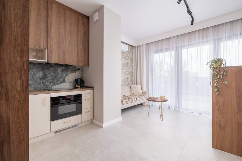 A modern kitchen nook with white cabinets and marble backsplash. Compact yet elegant in design.