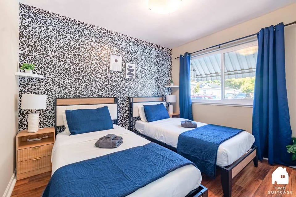 Bright room with two single beds, nightstands, and a window for natural light — ideal for friends or family.