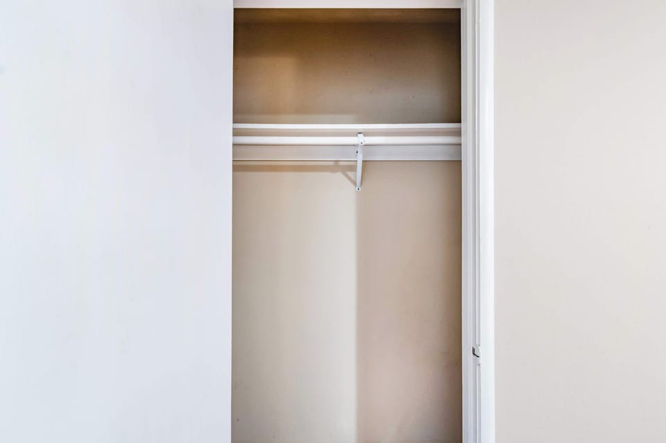 Closet area with hangers and shelves for easy storage.