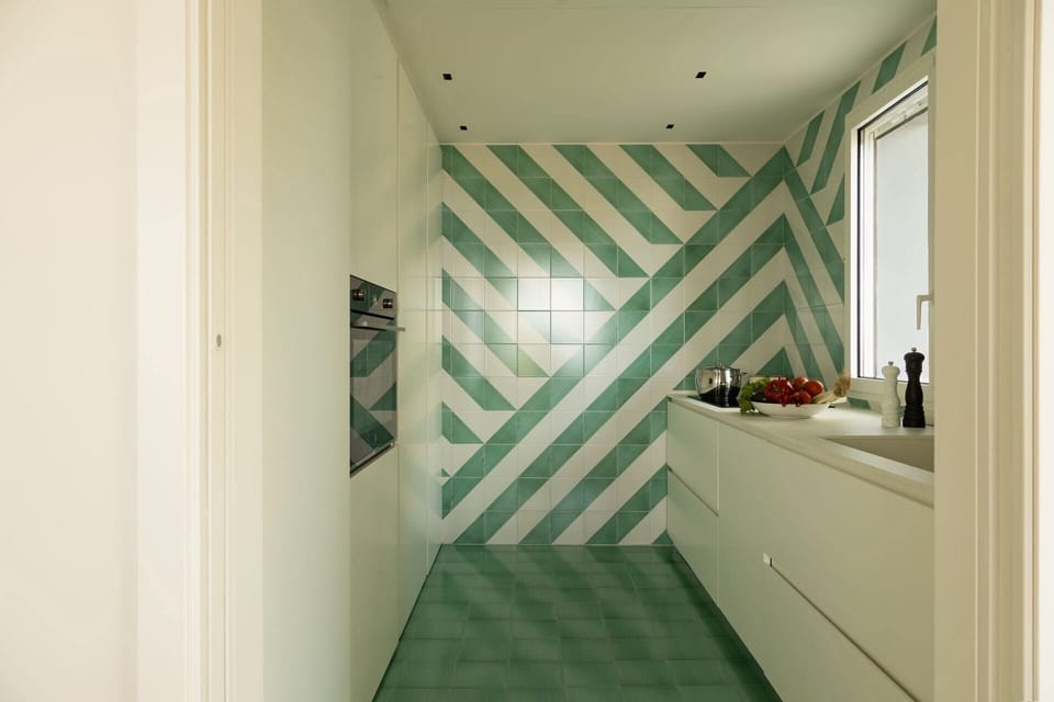 Another shot of the kitchen with its white-and-green, geometrically patterned tiles.