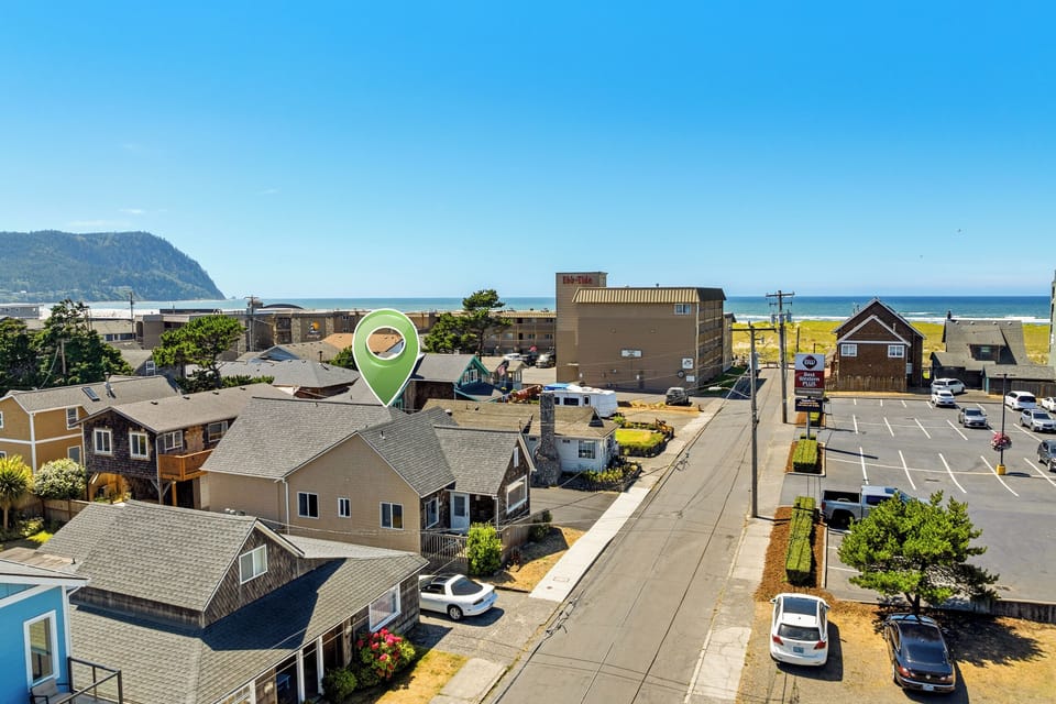 An aerial perspective of a coastal neighborhood showcasing the property's proximity to sandy beaches, ocean views, and convenient access to nearby amenities and the waterfront.
