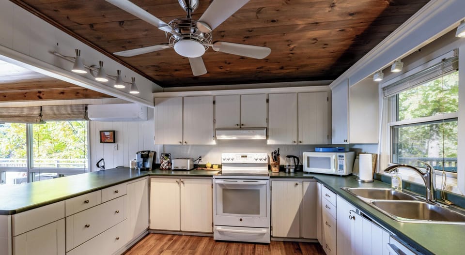 Bright, airy kitchen with rustic wood ceiling and modern amenities