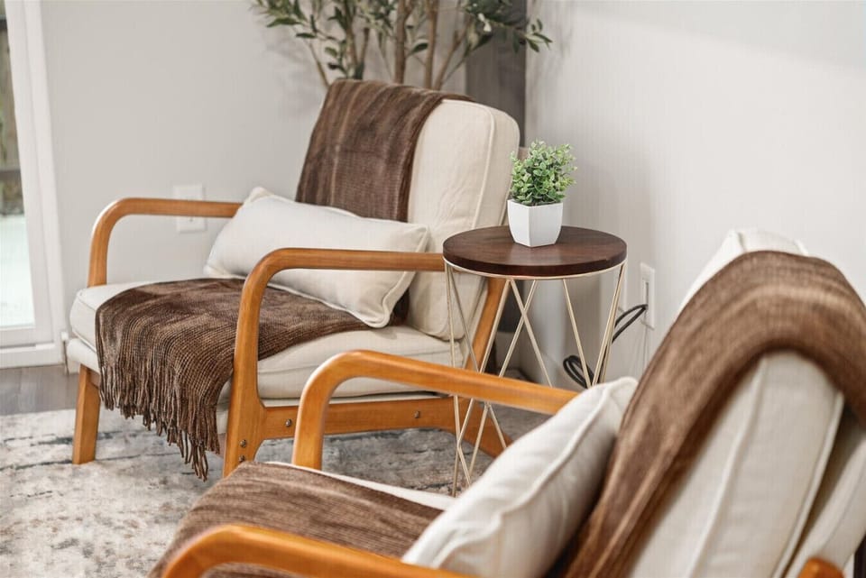 - Comfortable lounge setup with accent chairs and modern gold side table   - Potted greenery adds freshness and warmth to this relaxing corner   - Ideal spot to unwind after exploring local attractions and nearby parks