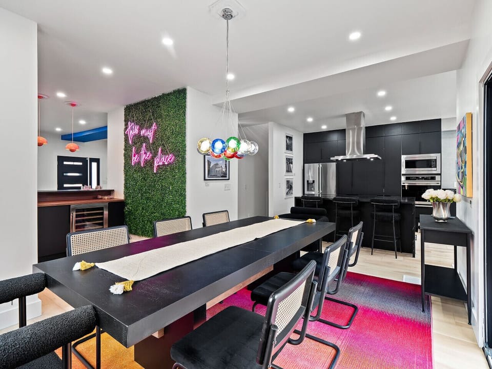 Spacious kitchen-dining layout w/ playful lighting & modern details.
