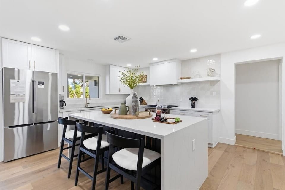 Fully equipped kitchen with stainless steal appliances and a kitchen island with bar seating for 3 guests.