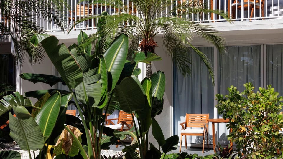 Sip morning coffee in a lush, shaded courtyard patio.