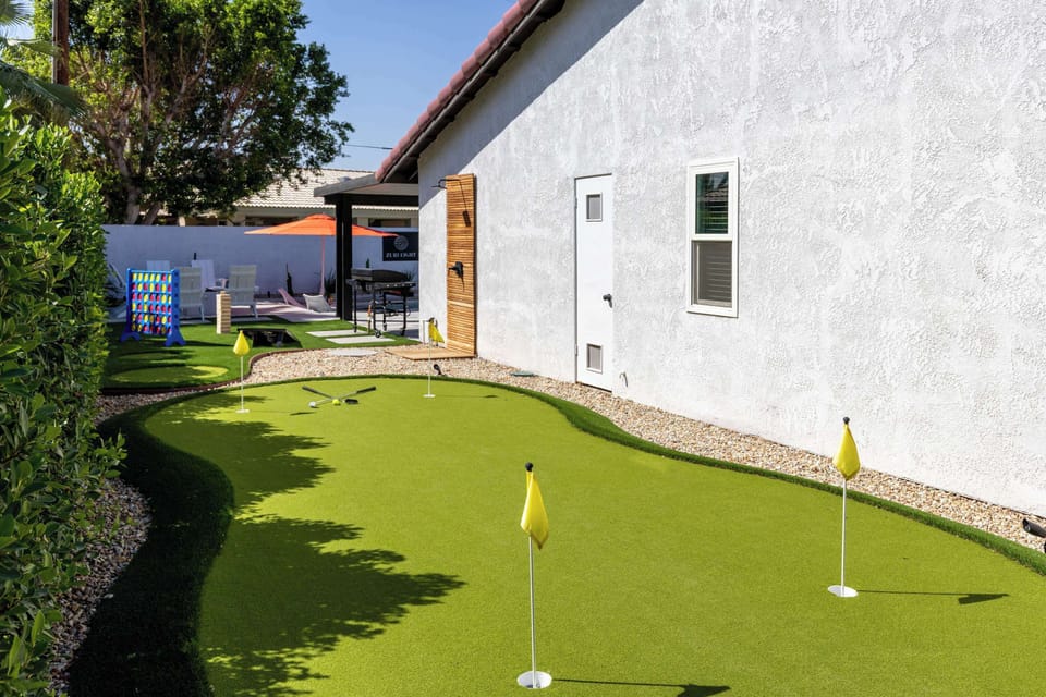Sunlit private putting green with multiple holes, giant Connect Four & lawn games — settle the score before dinner